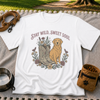 White T-shirt mockup featuring golden-coated dog beside floral cowboy boots and flowers beneath Stay Wild Sweet Soul.