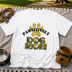 “Pawsitively Dog Mom” lettering in a camouflage treatment. On a White T-shirt.