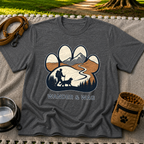 Dark Heather Grey T-shirt mockup featuring hiker and dog following a mountain trail framed inside a paw print.