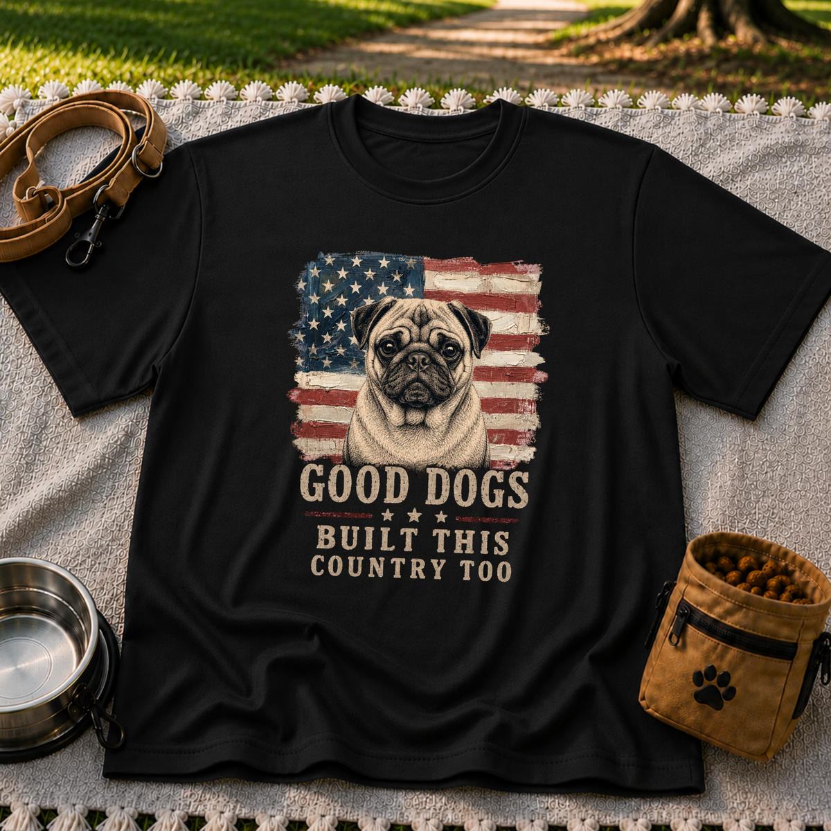 Black T-shirt mockup featuring pug portrait against a distressed American flag with patriotic lettering.