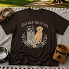 Dark Chocolate T-shirt mockup featuring golden-coated dog beside floral cowboy boots and flowers beneath Stay Wild Sweet Soul.