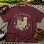 Maroon T-shirt mockup featuring golden-coated dog beside floral cowboy boots and flowers beneath Stay Wild Sweet Soul.