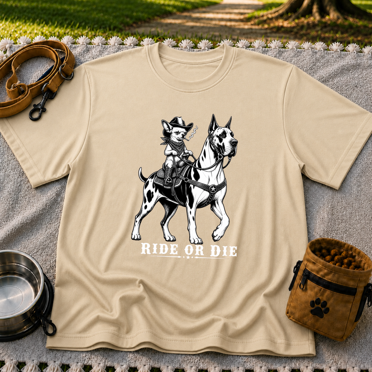 Sand T-shirt mockup featuring cowboy-hat Chihuahua riding a Great Dane above Ride or Die lettering.