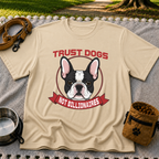Sand T-shirt mockup featuring French Bulldog portrait in a circular badge above a red Trust Dogs Not Billionaires ribbon.