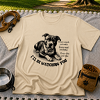 a watchful dog paired with a line about keeping an eye on you. On a Sand T-shirt.